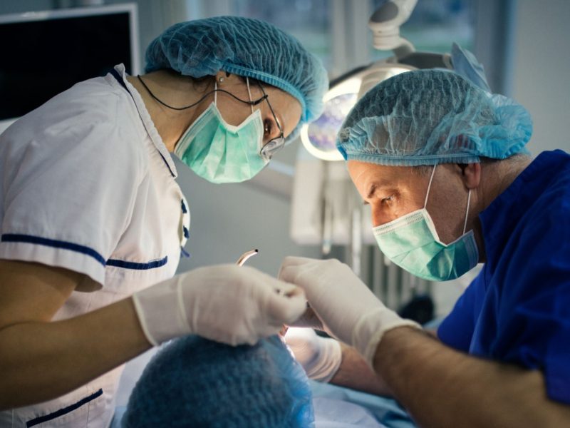 dentist, dental nurse undertaking dental surgery